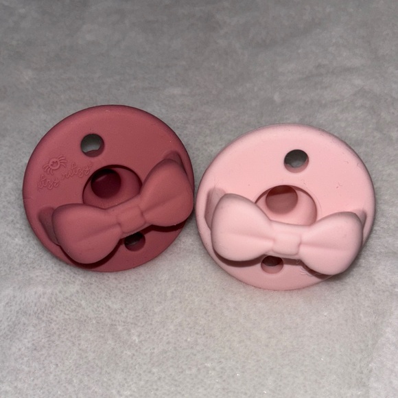 Itzy Ritzy Other - (2 for $10) Itzy Ritzy Bow Silicone Pacifiers - Pink and Rose